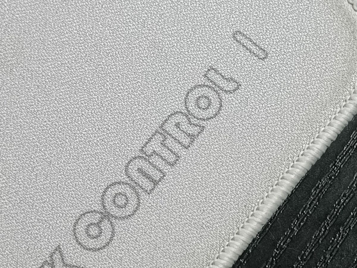 Detalle del logo PK Control en la tela de la alfombrilla